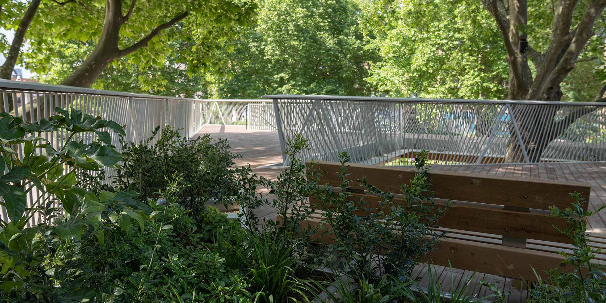 A view behind a bench facing the railing of a balcony.