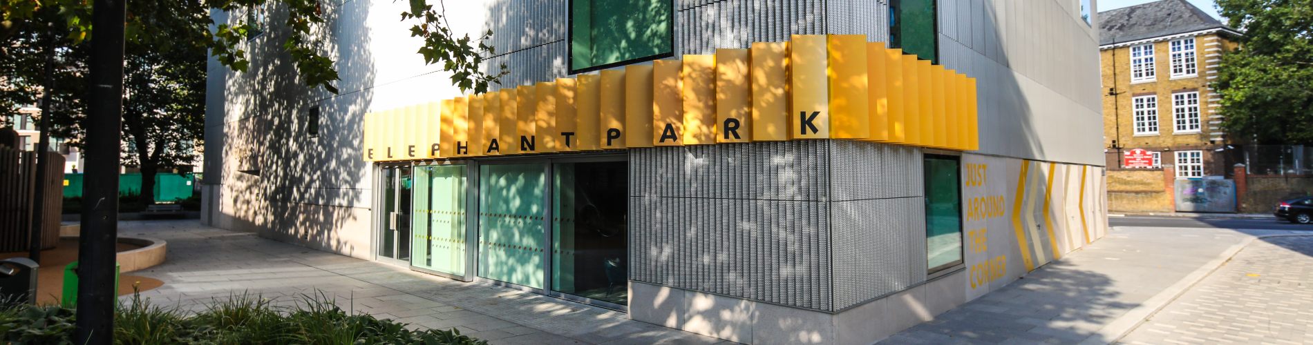 A grey building with a yellow Elephant Park sign above the doorway