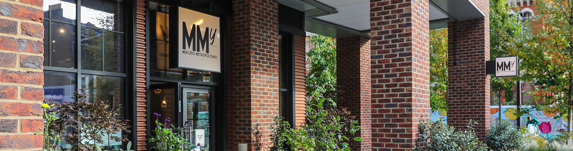 Stone pillars outside MM Factory with the white MM Factory sign above the door