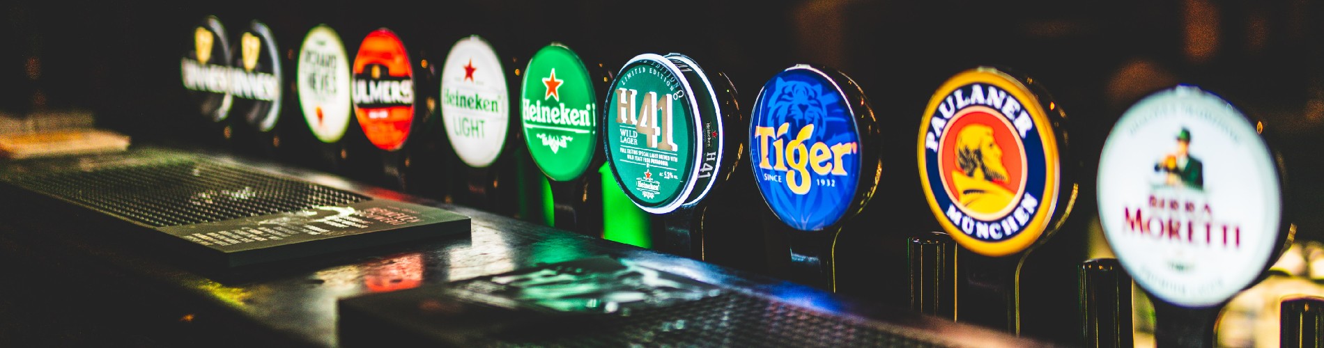 A row of beer taps in a pub with the logos facing the camera